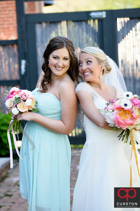Bride posing with a bridesmaid.