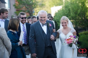 Bride and her father walking down the aisle at her outdoor wedding at Zen Greenville.