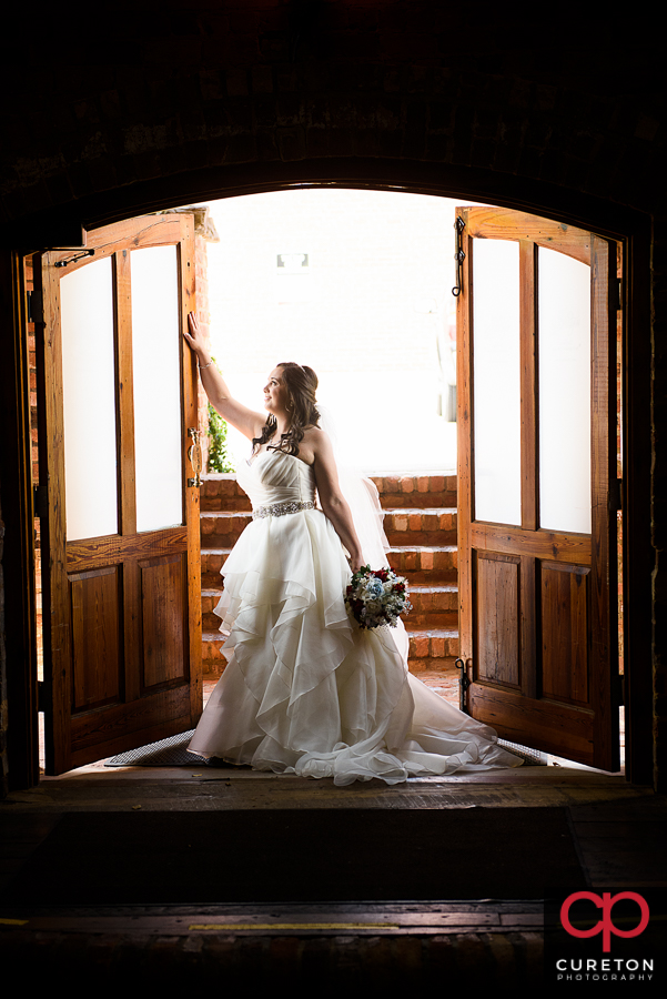 Bride holding onto the door during her Old Cigar Warehouse bridal session..