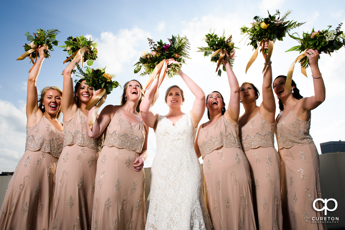 Bridesmaids throwing their flowers on a rooftop in Greenville.