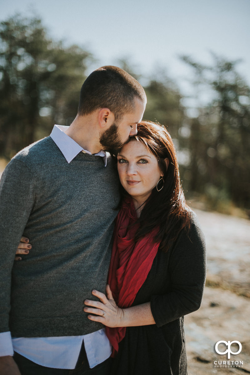 Man kissing his fiancee on the forehead during their engagement session at Bald Rock.