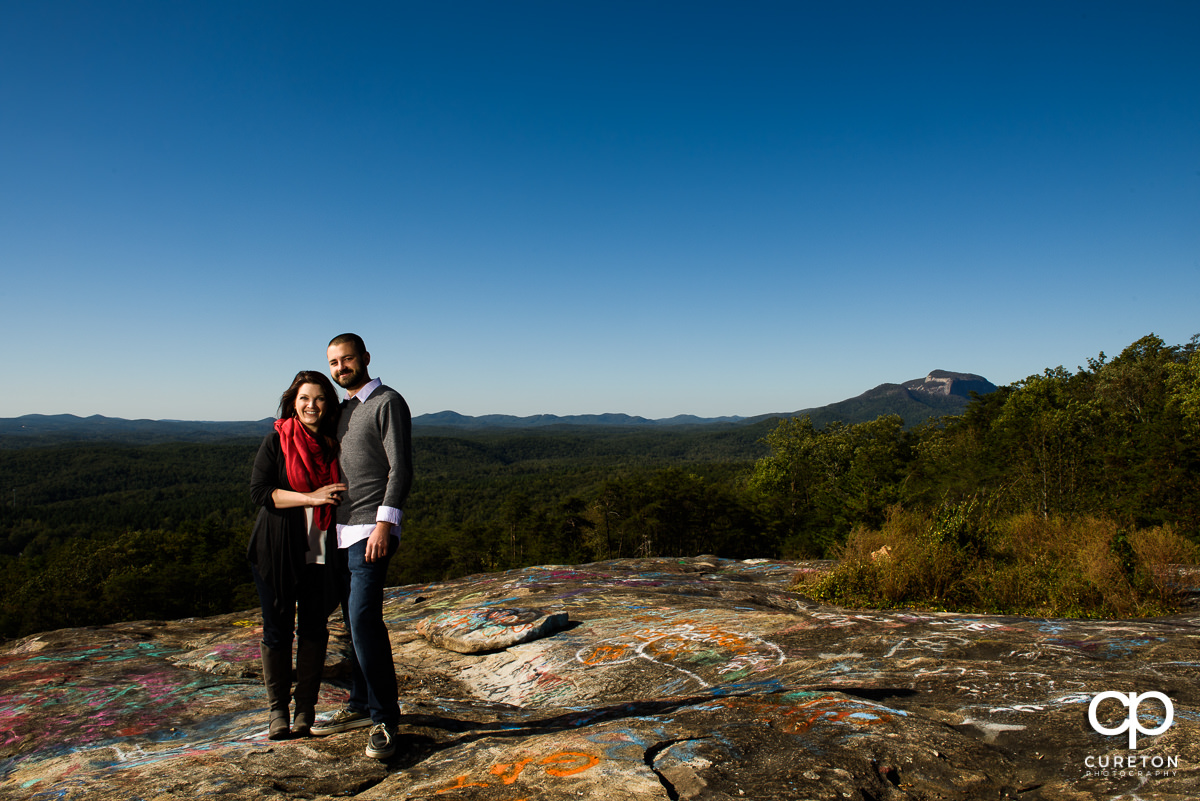 Man and his fiancee standing on Bald Rock during their engagement session.