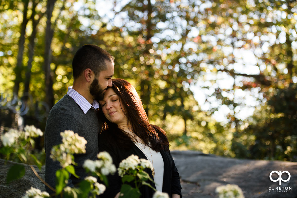 Future bride and groom cuddling in the mountains.