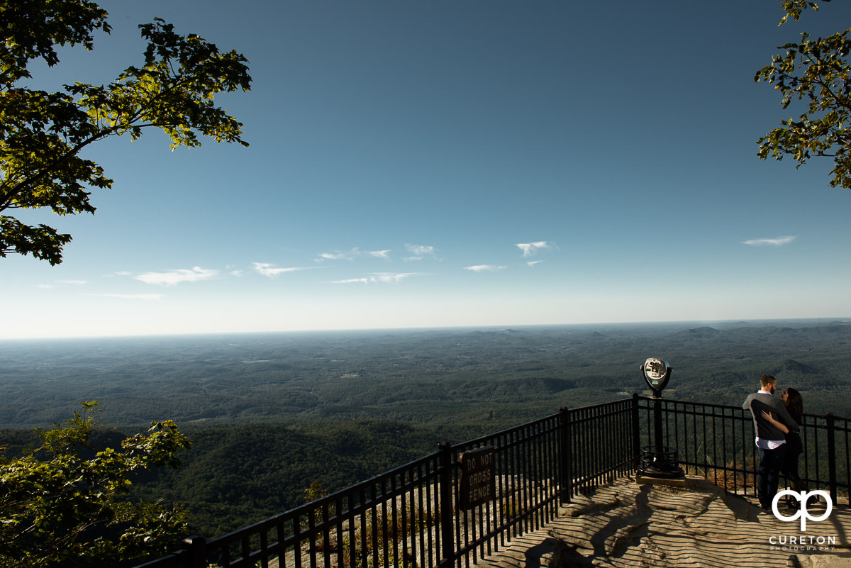 Engaged couple looking at each other at the lookout during their Caesar's Head engagement session.