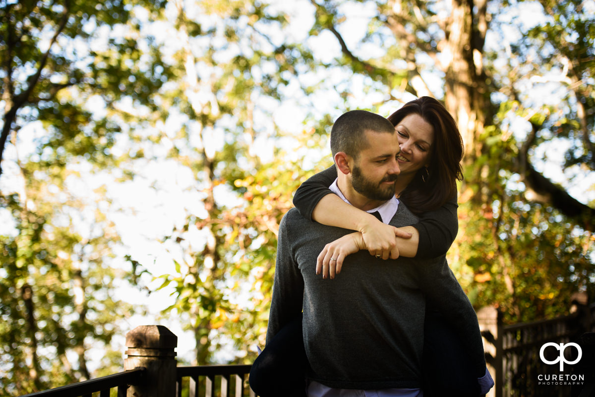 Future bride getting a piggyback ride from her fiancee.