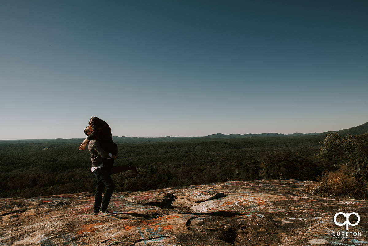 Man lifting his bride on Bald Rock.