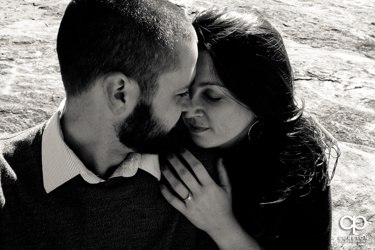 Engaged couple cuddling tight.