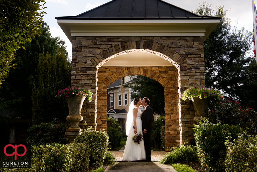 Bride and groom standing in an archway.