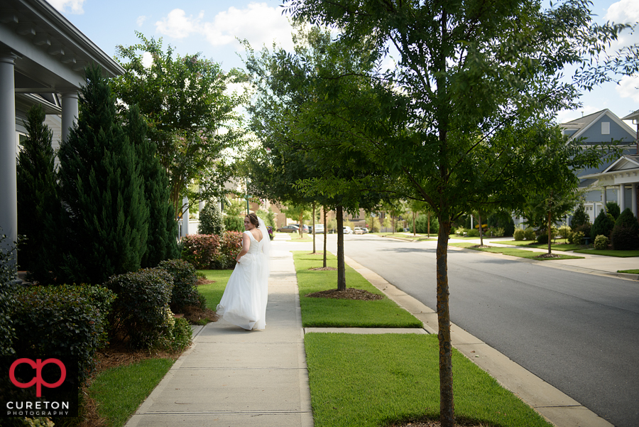 Bride walking down the sidewalk.