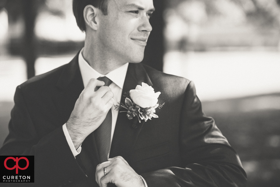 Groom straightening his tie.