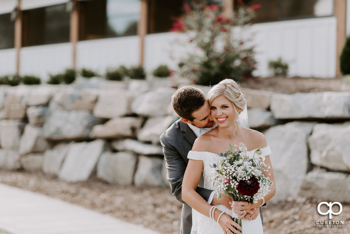 Groom snuggling with his bride at Chestnut Ridge in Canton,NC.