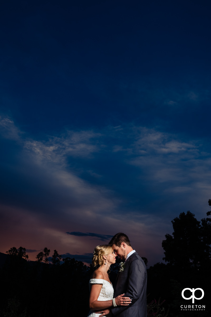 Bride and groom leading face to face at sunset after their wedding at Chestnut Ridge in Canton,NC.