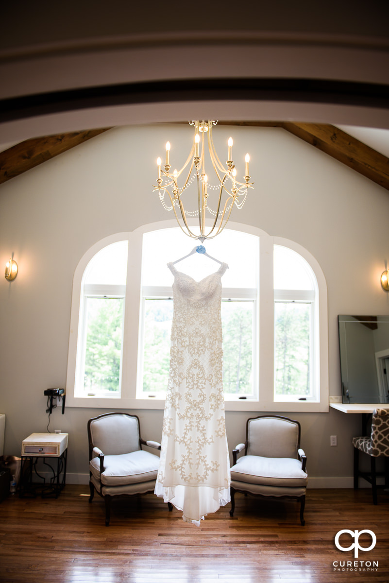 Wedding dress hanging on a chandelier.