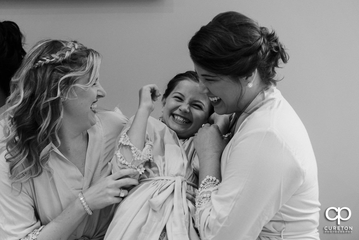 Bridesmaids laughing with the flower girl.