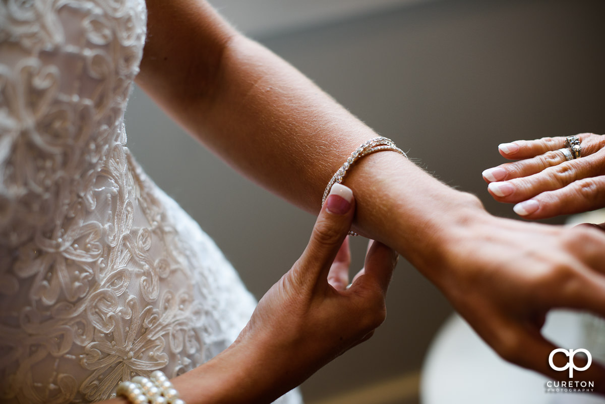 Bride putting on a bracelet.