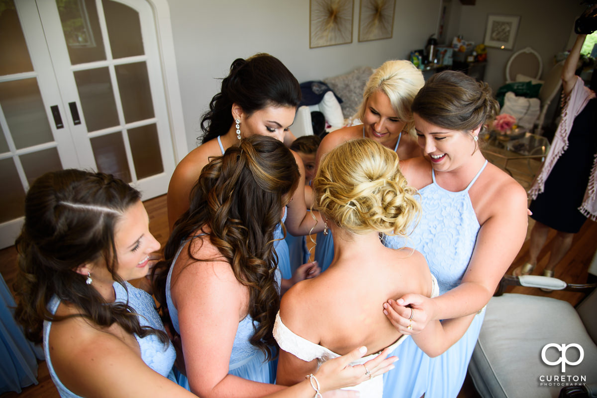 Bridesmaids hugging the bride.