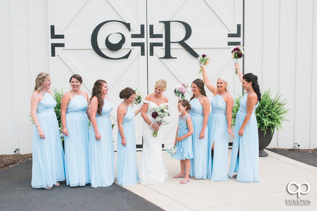 Bride laughing with her bridesmaids before the wedding ceremony at Chestnut Ridge.