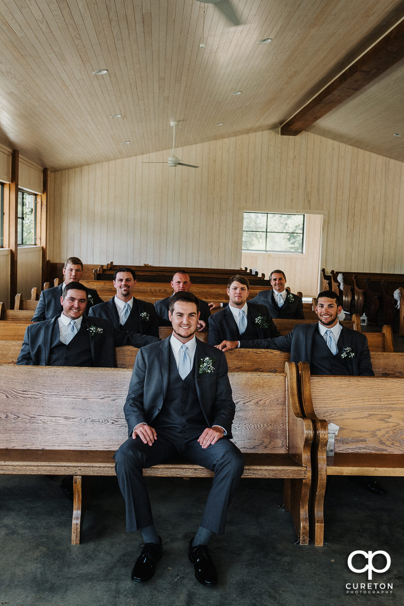 Groom and his grromsmen in the pews of the chapel at Chestnut Ridge.