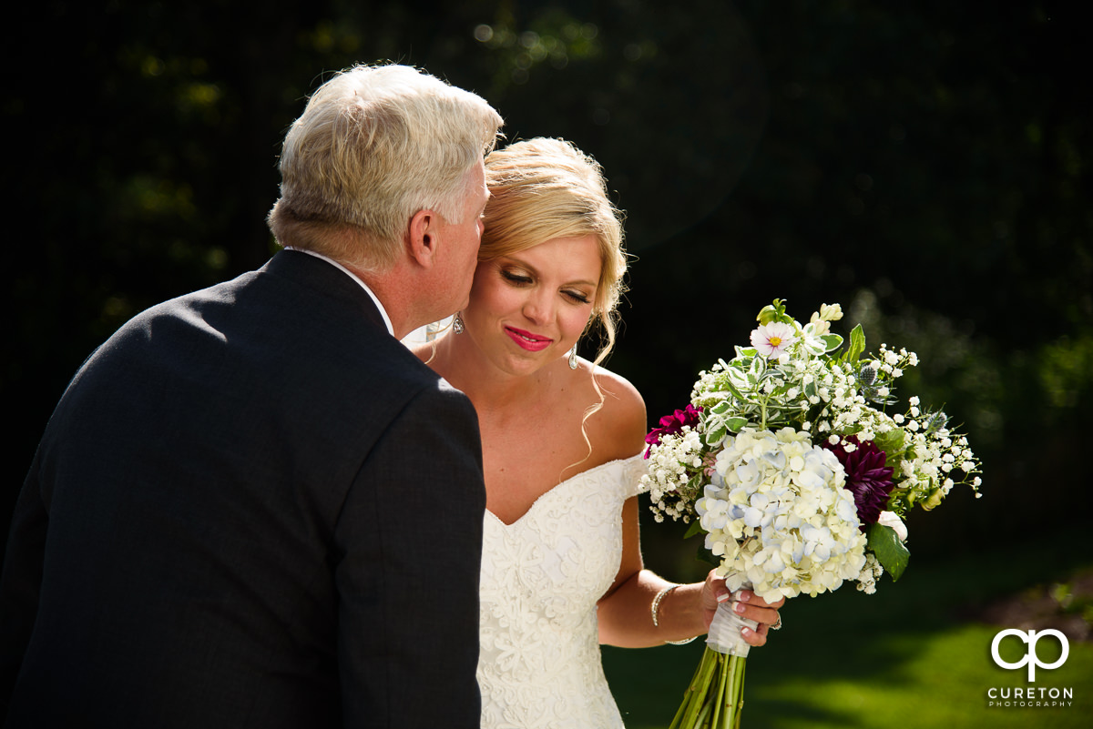 Bride and her father sharing a moment before walking down the aisle together.