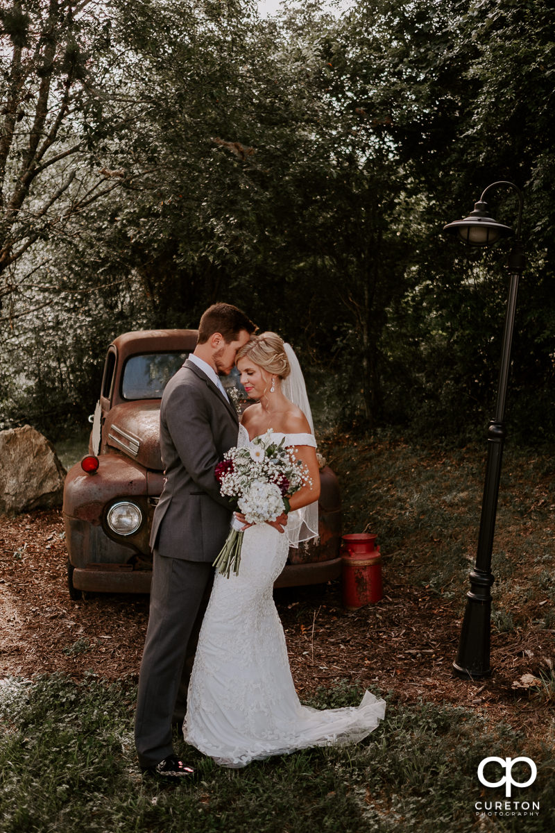 Bride and groom in front of a vintage pickup truck.