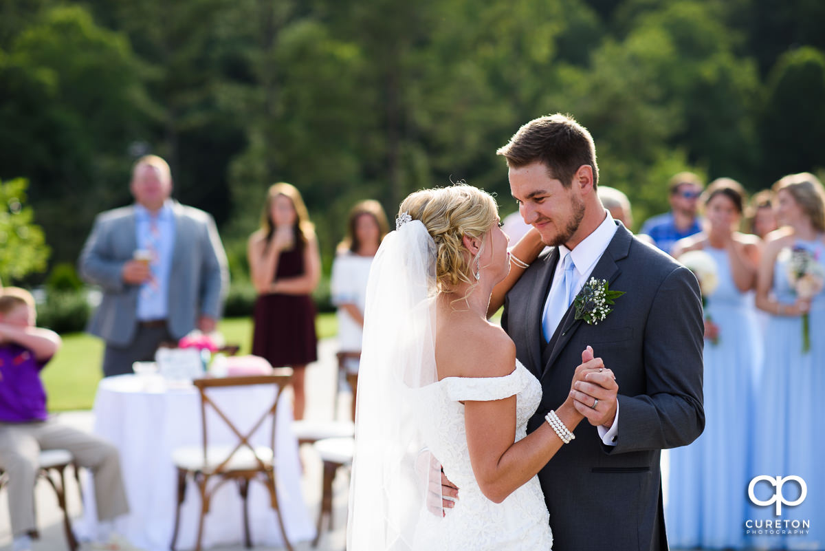 Groom smiling at his bride during the first dance at the wedding reception.