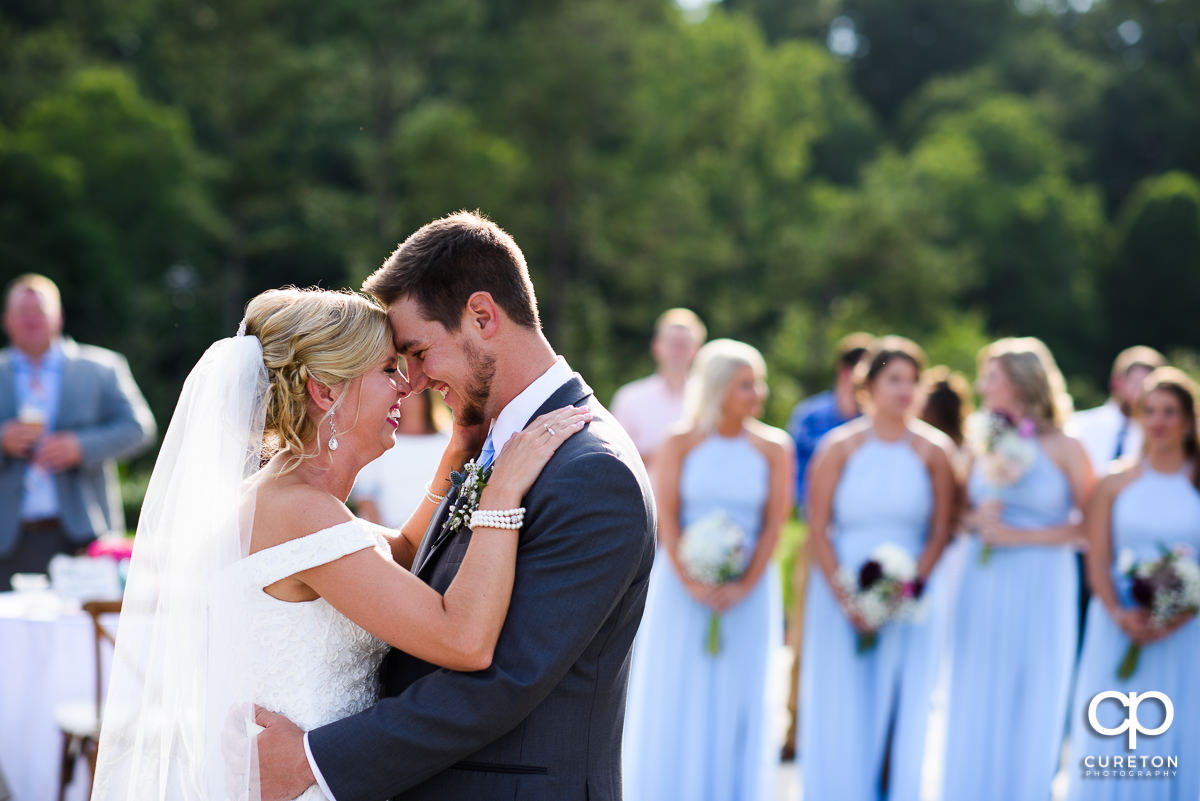 Newlyweds laughing during the first dance at the wedding reception.