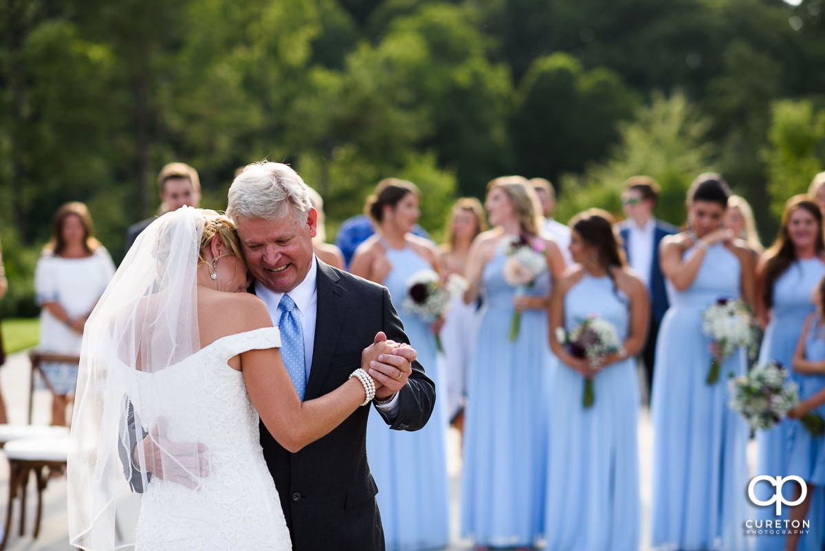 Bride's father smiling during the father-daughter dance.