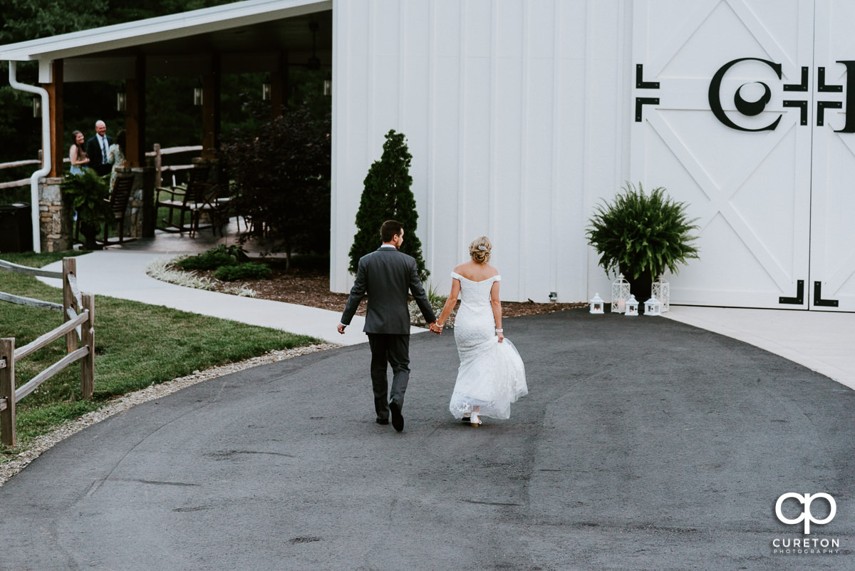 Newlyweds walking back to the barn reception.
