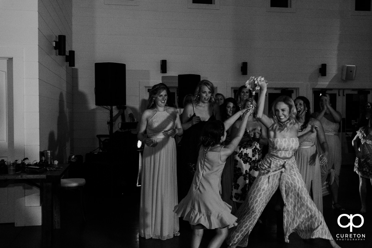 Bride's friend catching the bouquet.