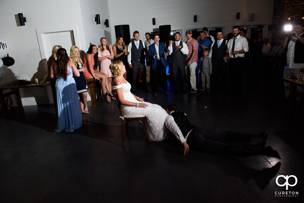 Groom taking off the garter.