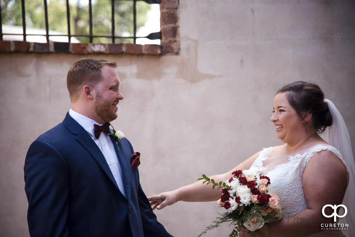 Bride and groom smiling at each other at the first look before the Old Cigar Warehouse wedding ceremony.
