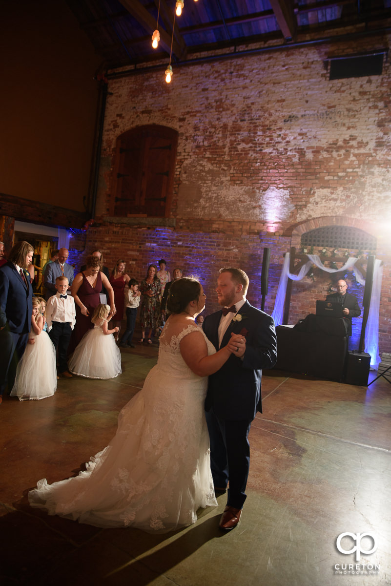 Bride and groom sharing a dance at the wedding reception in Greenville at The Old Cigar Warehouse.