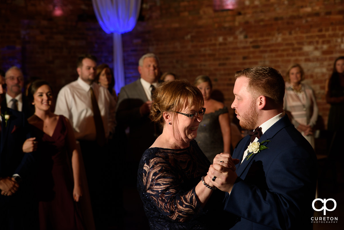 Groom dancing with his mom at the wedding reception in Greenville at The Old Cigar Warehouse.