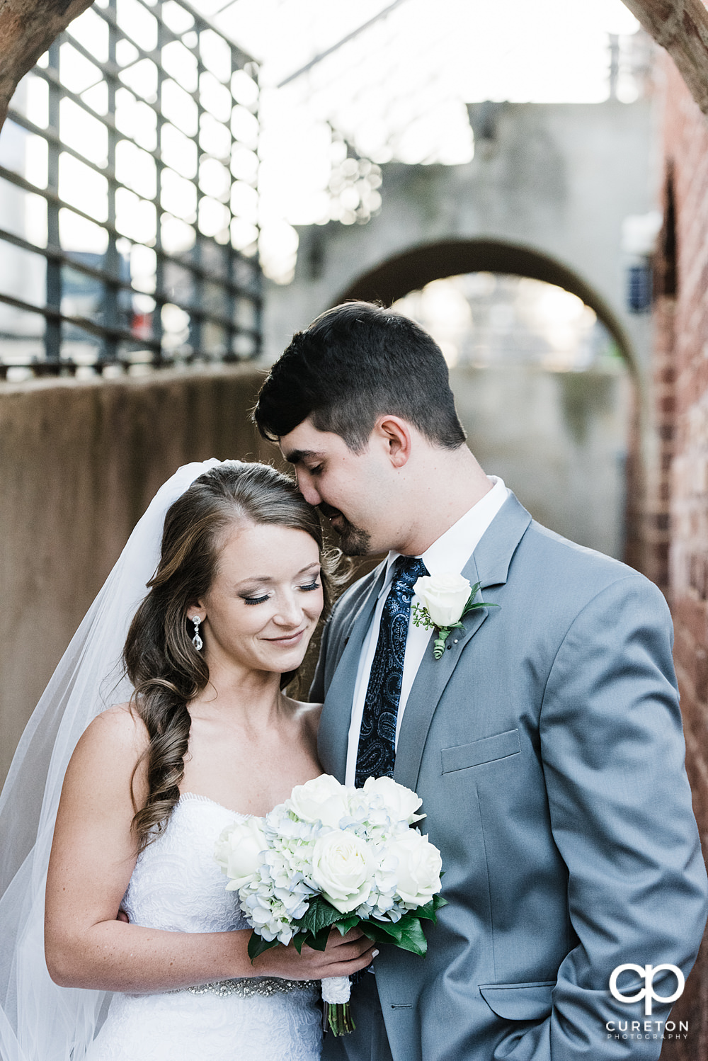 Bride and groom snuggling after their wedding at The Old Cigar Warehouse in downtown Greenville,SC.