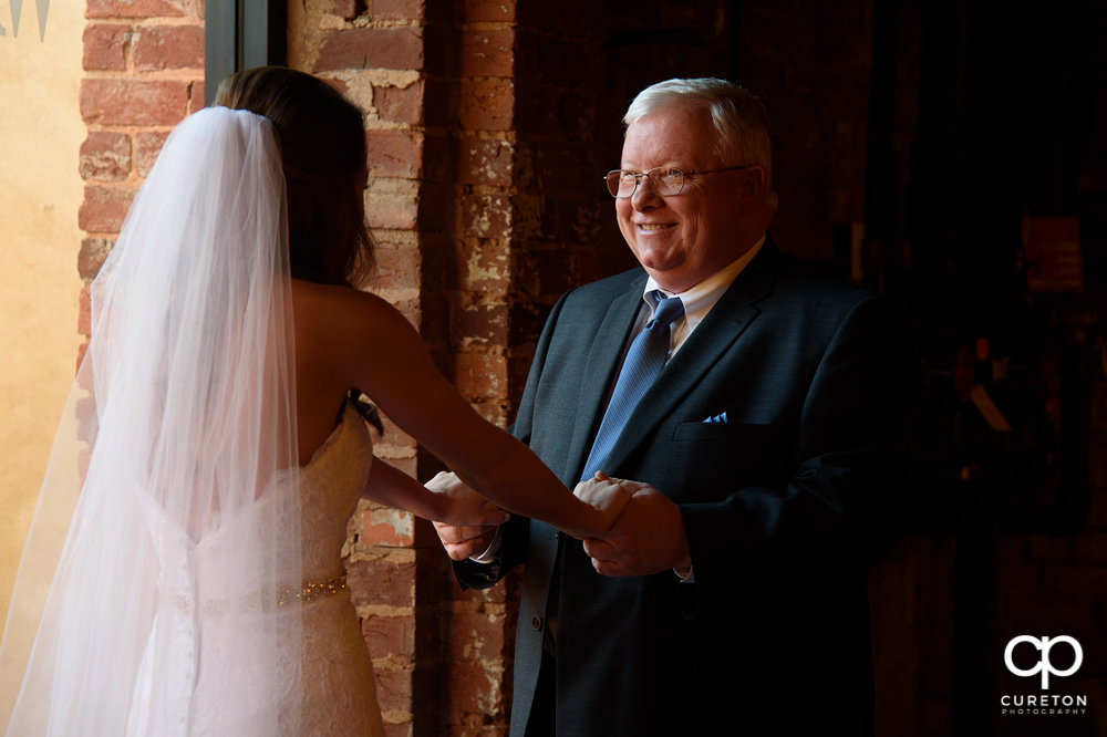 Bride's father sees her in the dress for the first time.
