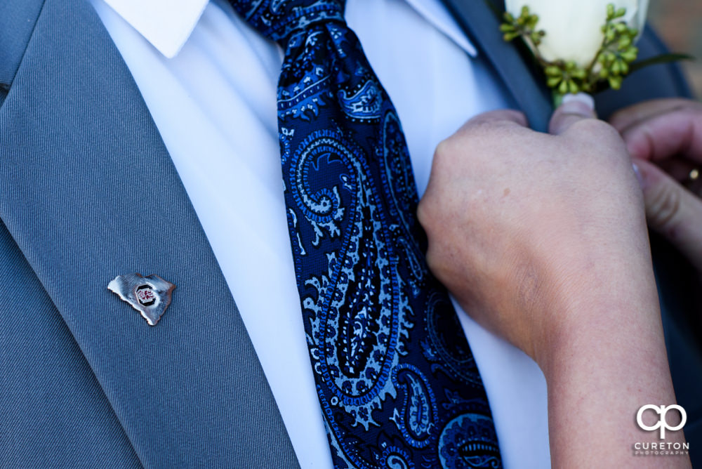 Groom adjusting his tie.