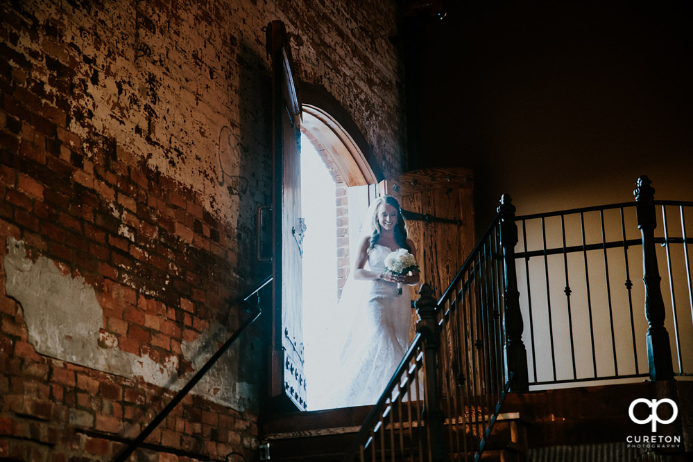 Bride wlaking down the stairs at the Old Cigar Warehouse.