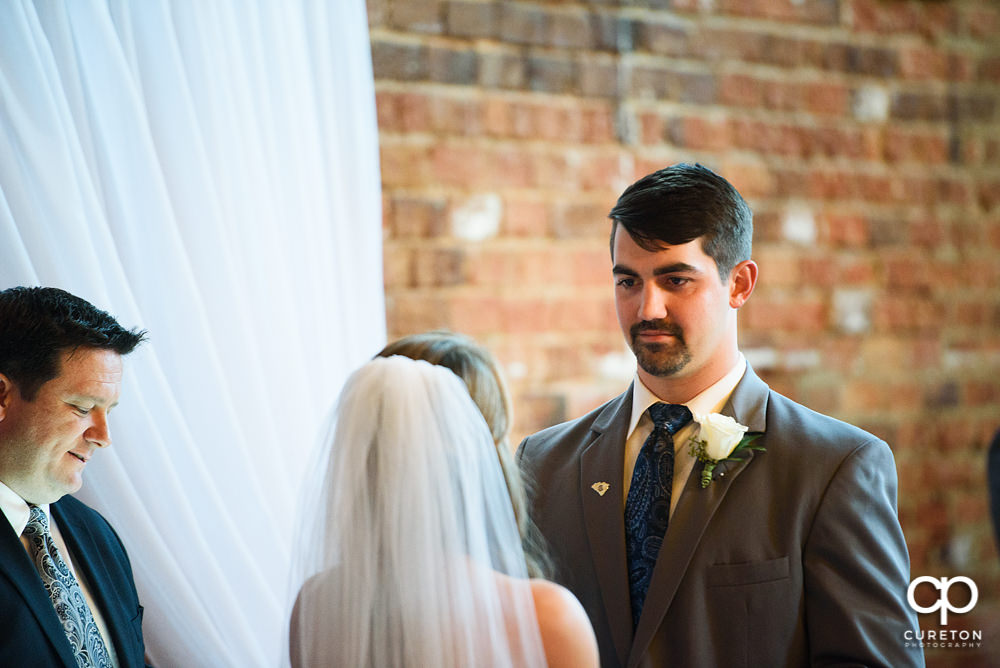 Groom looking at this bride during the ceremony.
