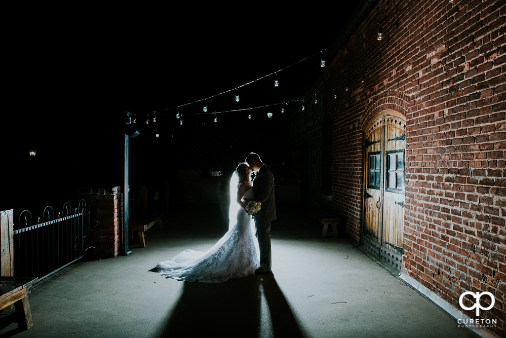 Bride and groom on the deck of Old Cigar Warehouse at night.