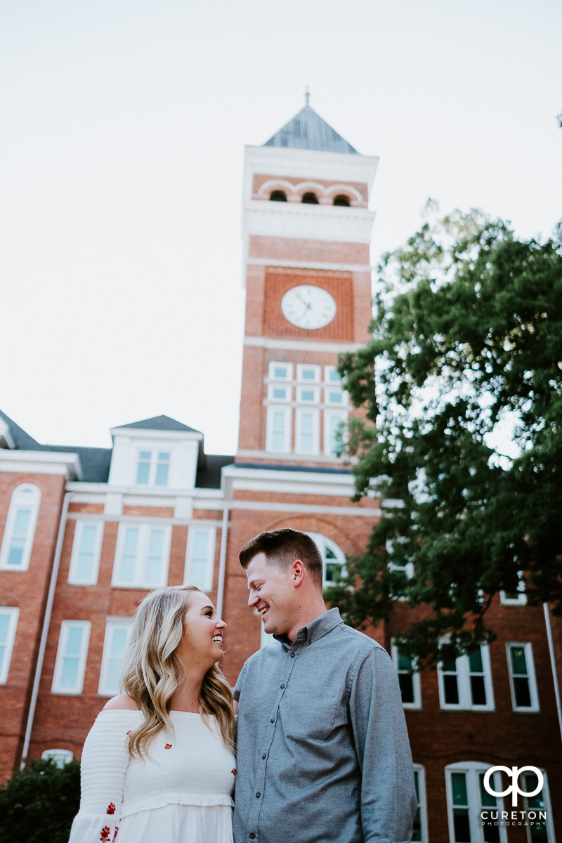 Engaged couple staring into each other's eyes in front of Tillman Hall during a Clemson engagement session.