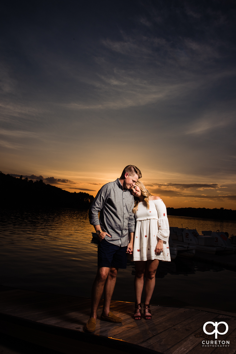 Engaged couple by the lake during an amazing Clemson sunset.