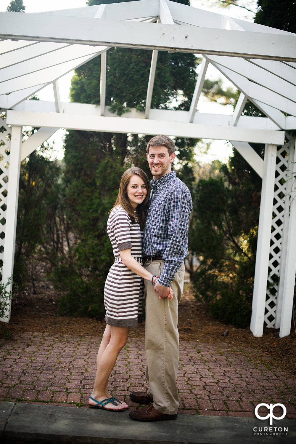 Future bride and groom smilin during an engagement session at the Botanical Gardens in Clemson.