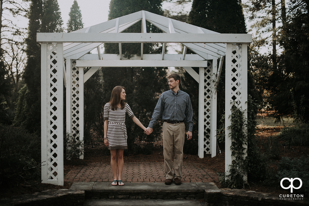 Engaged couple looking at each other during an engagement session at the Botanical Gardens in Clemson.