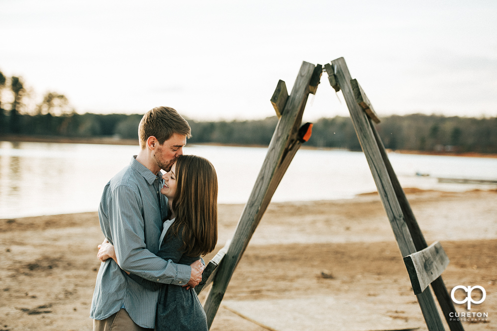 Couple kissing during an engagement session at the lake in Clemson.