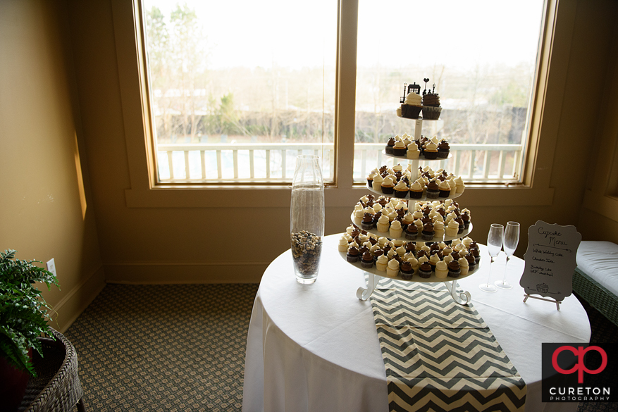Teh bride and groom share a cupcake.