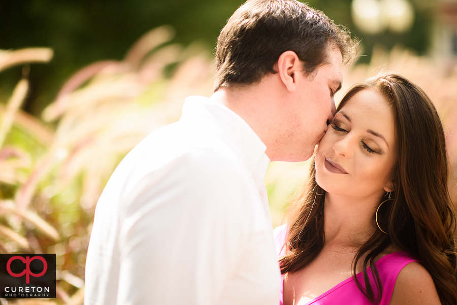 Groom kissing his bride to be during a Clemson University engagement session.