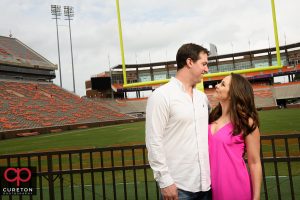 Bride and groom looking at each other on the Clemson football field.