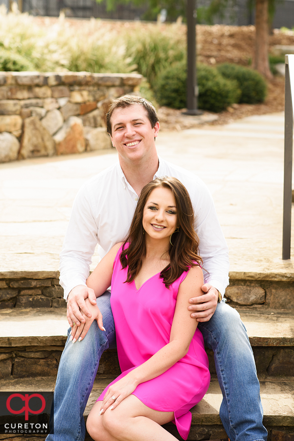 Engaged couple sitting on the steps.