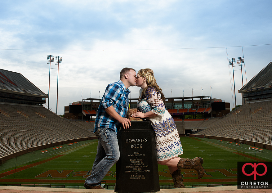 Couple kissing at Howard's rock during a Clemson stadium engagement session.