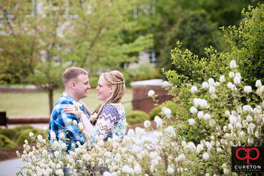Engaged couple in the flowers near Tillman Hall.